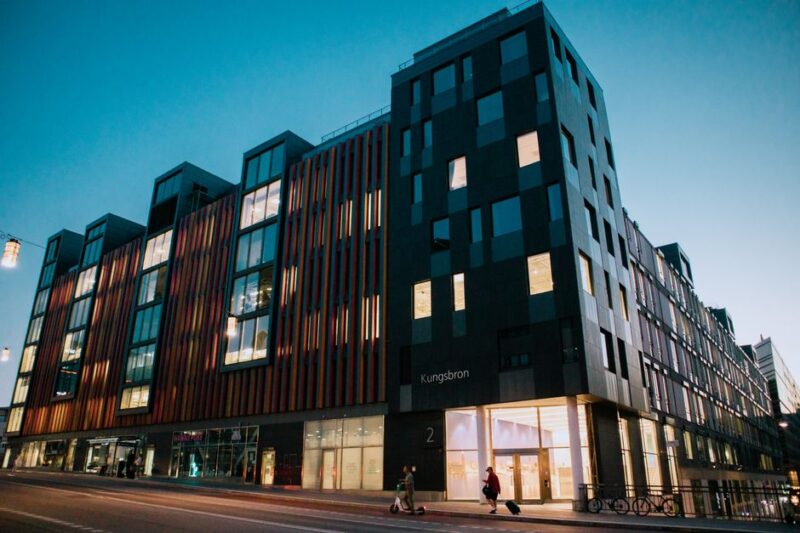 Twilight view of a modern office building in cityscape with vibrant sky.